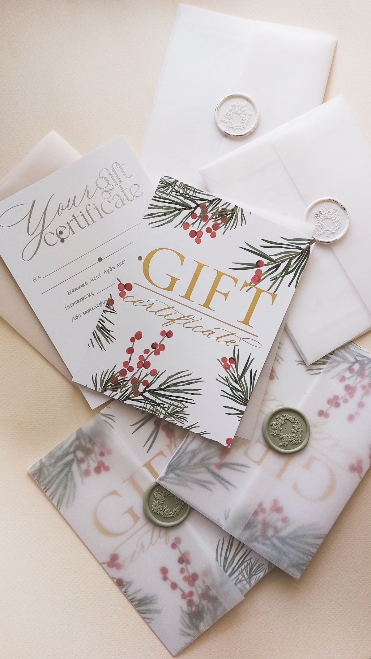 Geschenk- und Zertifikatskarten mit floralen Tannenzweig- und Beerenmotiven sowie Umschlägen mit Wachssiegeln auf hellem Untergrund